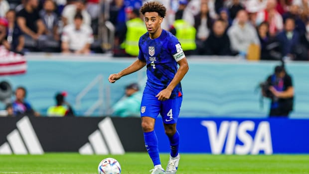 USMNT midfielder Tyler Adams looks to pass vs. England.